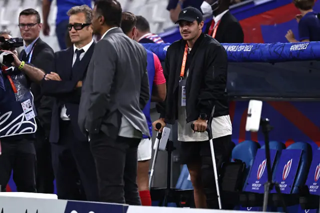 France's injured fly-half Romain Ntamack looks on from the touchline