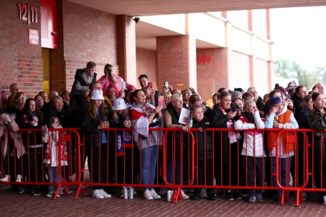 England fans wait outside the players entrance to welcome the England bus.