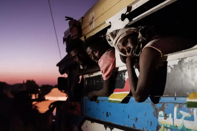 Ethiopian refugees who fled Ethiopia's Tigray conflict arrive by bus from Village Eight transit centre near the Ethiopian border at the entrance of Um Raquba refugee camp in Sudan's eastern Gedaref state, on December 11, 2020.