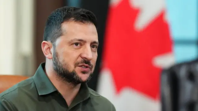 Zelensky in the foreground, a Canadian flag blurred in the background