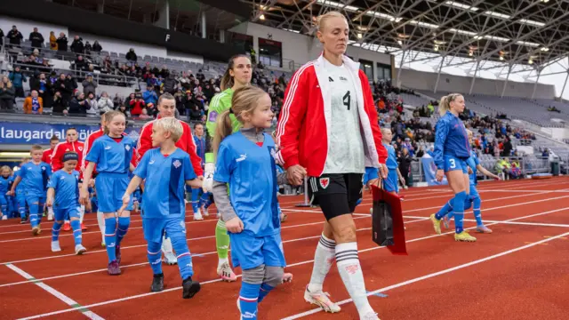 Sophie Ingle leads the Wales team out in Iceland