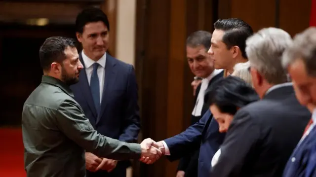 Ukraine's President Volodymyr Zelenskiy, flanked by Canadian Prime Minister Justin Trudeau, shakes hands with Conservative Party of Canada leader Pierre Poilievre in Ottawa