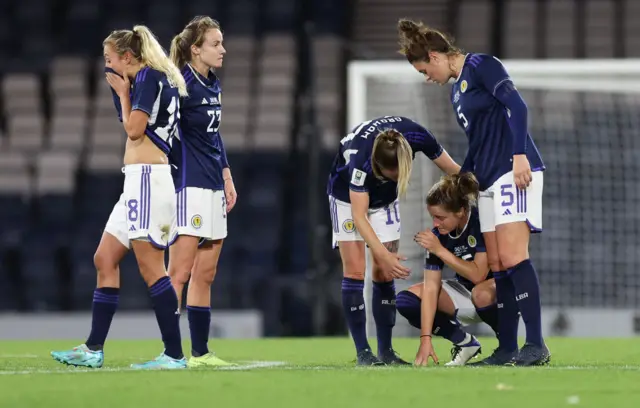 Scotland players console one another after missing World Cup qualification.