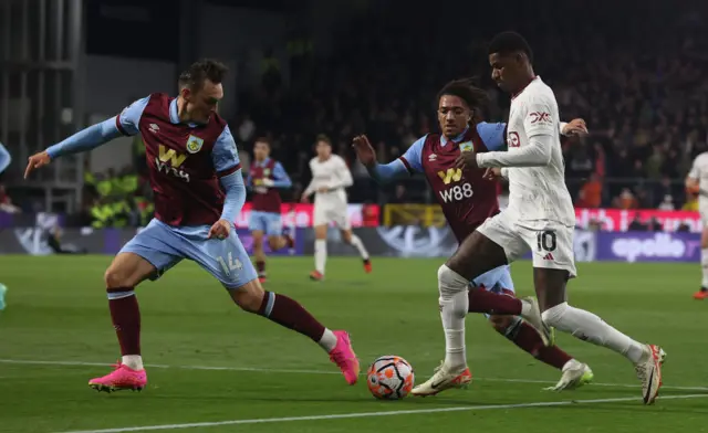 Rashford runs at pace towards two Burnley defenders.