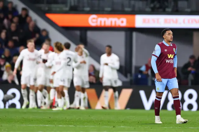 Ramsey stands dejected as United celebrate their goal in the distance.