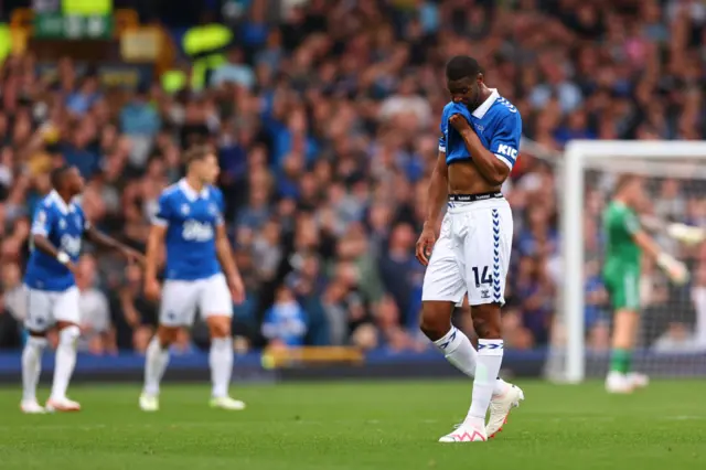 Beto holds his shirt to his face after Eveton concede. Teammates look dejected in the background.