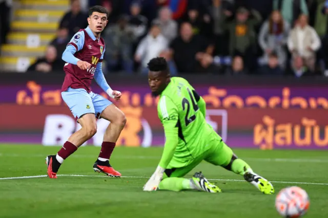 Amdouni and Onana watch the ball roll towards goal.