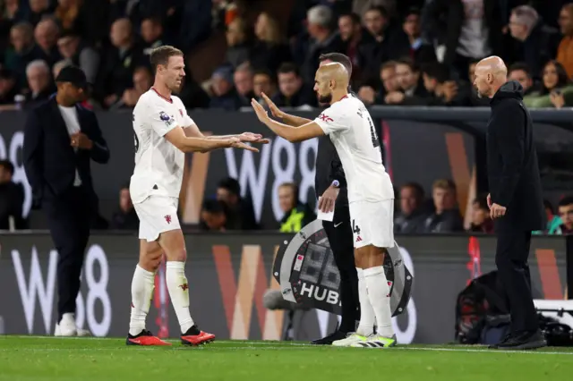 Evans and Amrabat shake hands as the latter is subbed on for the former.