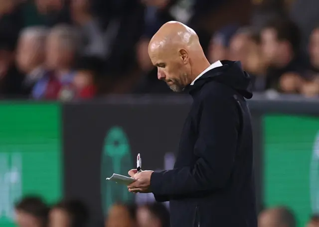 Ten Hag scribbles furiously with a four colour pen on the touchline.