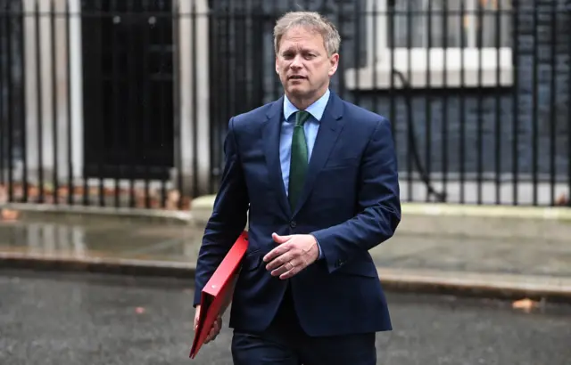 Grant Shapps holding a red binder outside Downing Street in January 2023