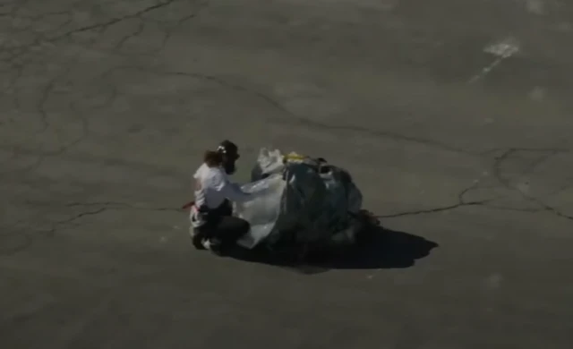 A crew member unpacking the capsule from its protective covering