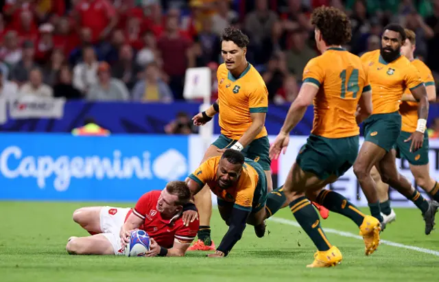 Nick Tompkins of Wales slides on top of the ball to score