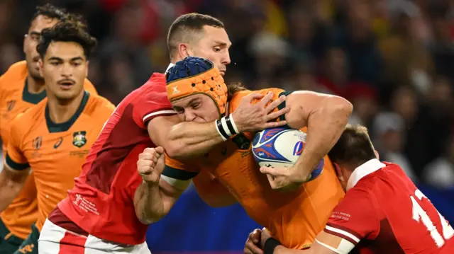 Wales' centres Nick Tompkins and George North tackles Australia's lock Tom Hooper