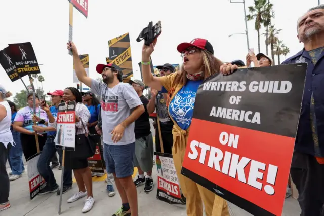 A group of protestors holding signs that say 'on strike'