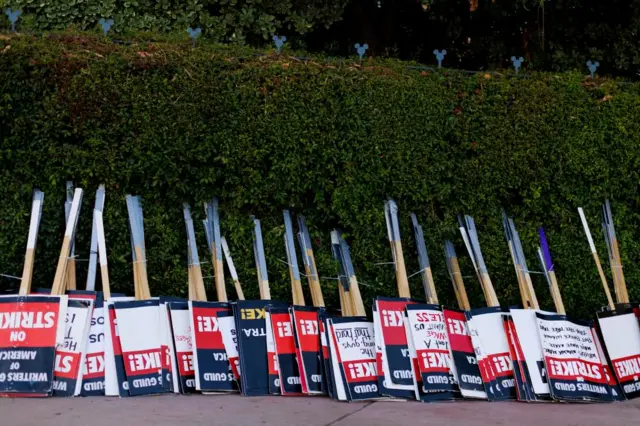 Writers Guild of America signs left in front of a hedge