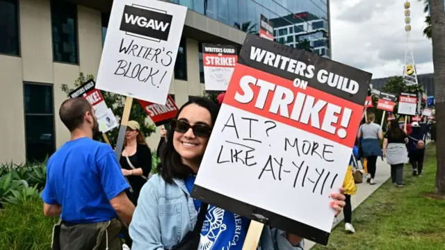 Writer Ilana Pena holds her sign on the picket line that reads AI? More like Ay yi yi