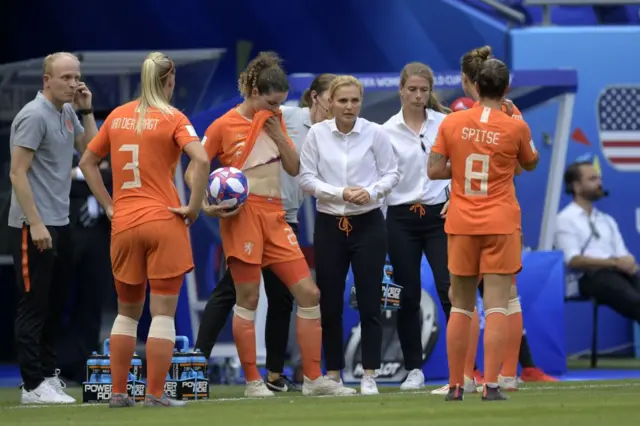 Sarina Wiegman gives instructions to Netherlands players on the touchline.