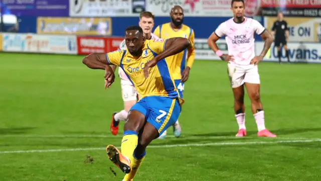 Mansfield forward Lucas Akins scoring from the penalty spot against Peterborough