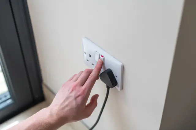 Person using electricity socket (stock image)