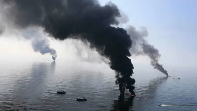 Smoke billows from a controlled burn of spilled oil off the Louisiana coast in the Gulf of Mexico coast line June 13, 2010.