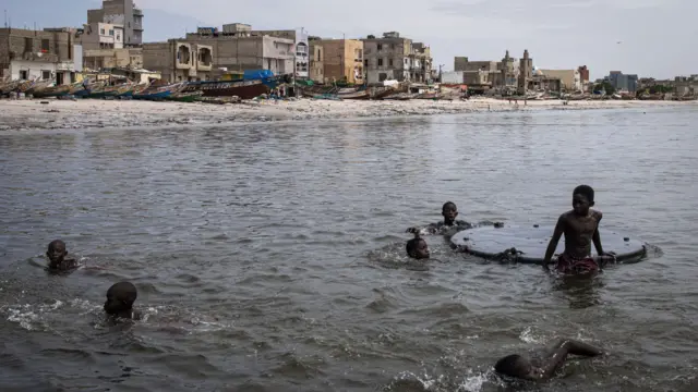 Young boys swim along the polluted Hann Bay in Dakar - 27 September 2023