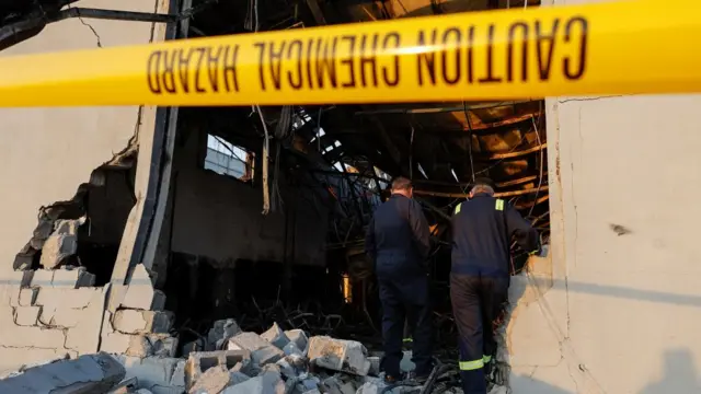 Officials walk through the rubble at the site following a fatal fire at a wedding celebration, in the district of Hamdaniya in Iraq's Nineveh province, Iraq, September 27, 2023.