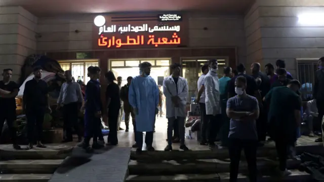 People wait outside hospital after Niniveh wedding hall fire in Iraq