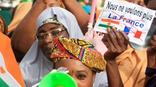 A person holds a paper that reads: "We no longer want France" during a demonstration outside the French army's headquarters in Niamey, Niger - 30 August 2023