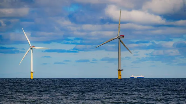 A ship passing wind turbines at Gwynt y Mor off the coast of Wales