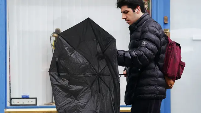 A man struggles with his umbrella in Dublin city centre as Storm Agnes lands