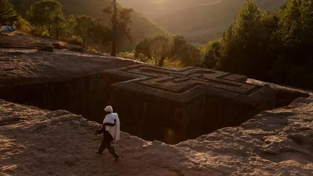 An Ethiopian Orthodox pilgrim walks past the St.George Rock-Hewn church ahead of the Ethiopian Christmas Eve celebration in Lalibela, Ethiopia January 6, 2023