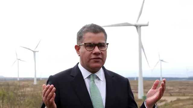 Alok Sharma in front of wind turbines