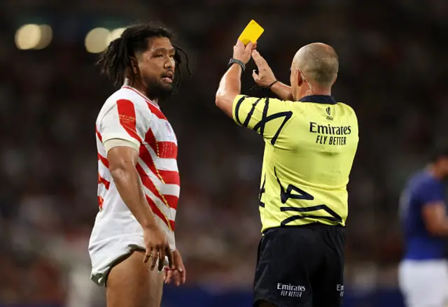 Referee Jaco Peyper shows a yellow card to Shota Horie