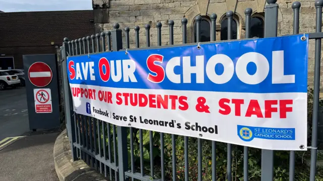 Save our school banner on a school building