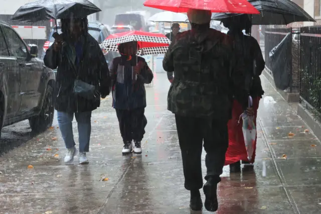 People walking through the torrential rain on Friday morning