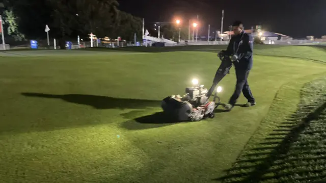 A member of staff mows the chipping green area