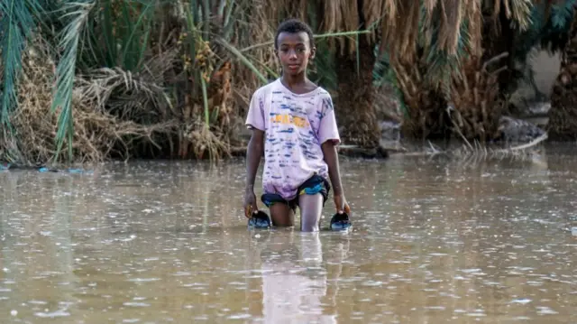 A boy walks through a flooded area in al-Sagai north of Omdurman on 6 August.