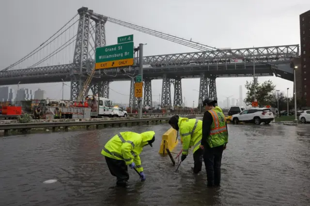 New York City Department of Environmental Protection workers attempt to clear blocked drains at the FDR Drive in Manhattan near the Williamsburg bridge