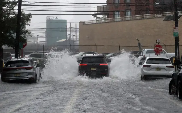 A car drives through a flooded street in Hoboken, NJ