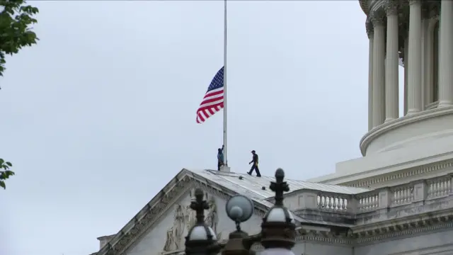 Outside the US Capitol building, where Congress meets, workers have just lowered the flag to half mast in tribute.