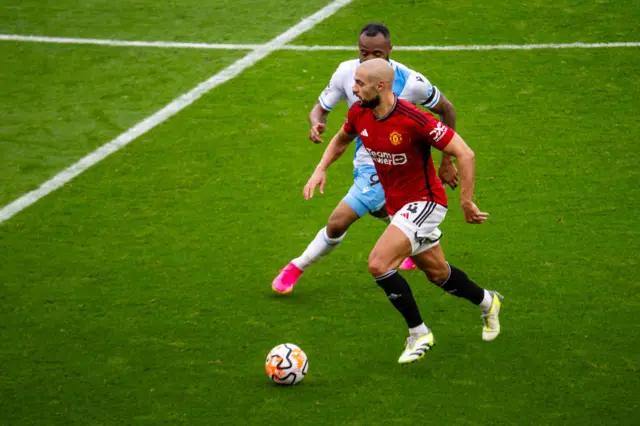 Sofyan Amrabat competes for the ball with Jordan Ayew