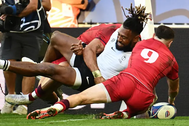 Fiji's centre Waisea Nayacalevu scores a try while being tackled by Georgian players