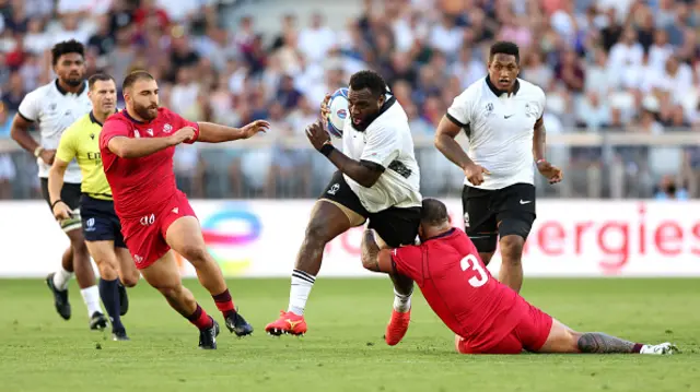 Luke Tagi of Fiji is tackled by Beka Gigashvili of Georgia