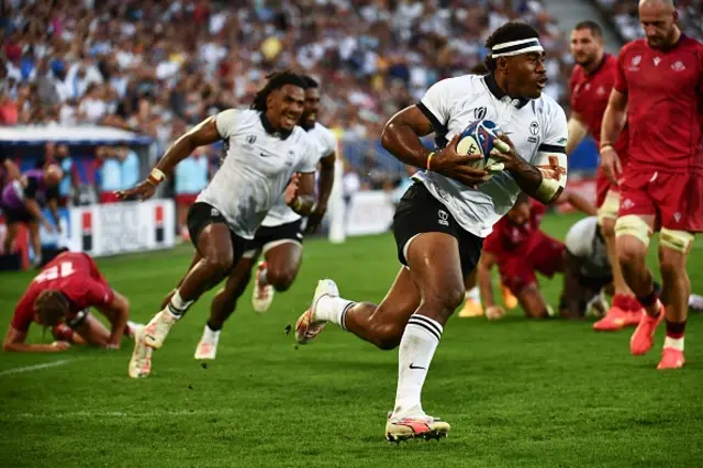 Fiji's wing Vinaya Habosi runs to score a try during the game
