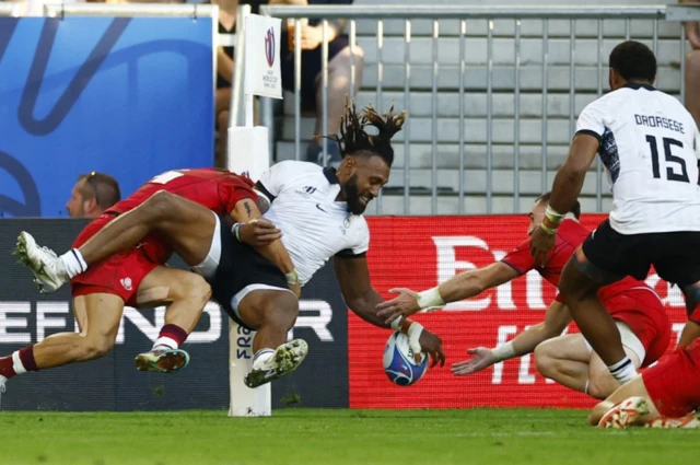 Fiji's Waisea Nayacalevu scores a try diving in the corner