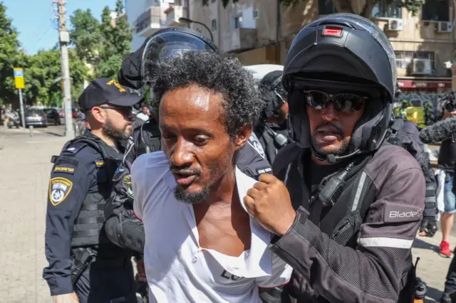 Members of Israel's security forces detain Eritrean asylum-seekers protesting an event organised by Eritrea's government in the coastal city of Tel Aviv on September 2, 2023.