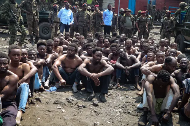 People arrested during a military operation to prevent a planned demonstration against the United Nations by a religious sect, sit on the ground and guarded by the army in Goma, eastern Democratic Republic of Congo - 30 August 2023