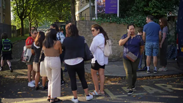 Parents outside St Martin's in the Field Girls' School in London, where pupils from Corpus Christi Catholic School are relocated