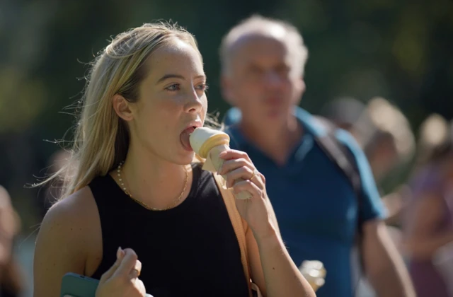 Woman licks an ice cream at Green Park, central london