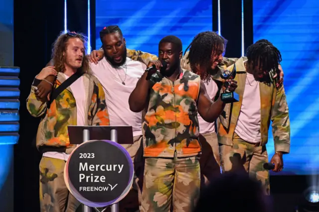 Members of Ezra Collective, Joe Armon-Jones, TJ Koleoso, Femi Koleoso, James Mollison and Ife Ogunjobi on stage after winning The Mercury Prize during The Mercury Prize 2023 awards show at Eventim Apollo